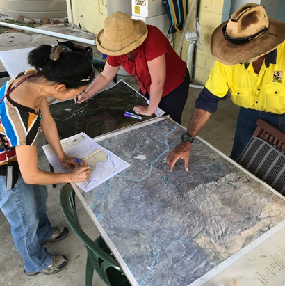Three people looking at maps.  Pictured L to R: CSIRO's Taryn Kong and Cathy Robinson with Ewamian elder Jimmy Richards. 