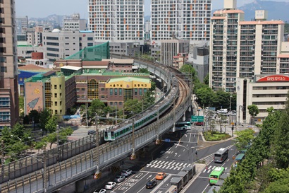 Image of train line, road and buildings in Korean city
