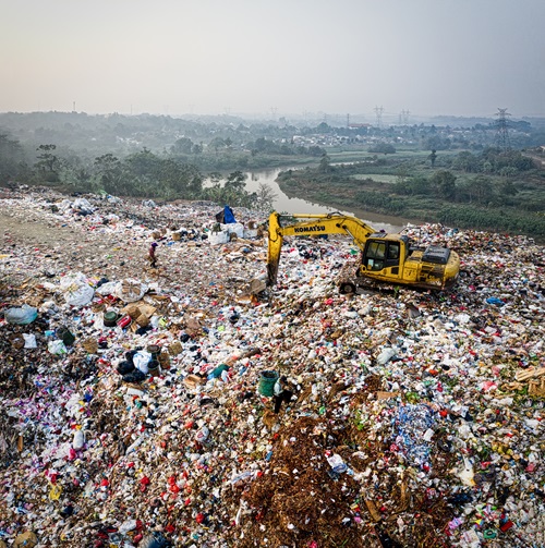 Image of large pile of waste in Indonesia - machinery being use to move debris