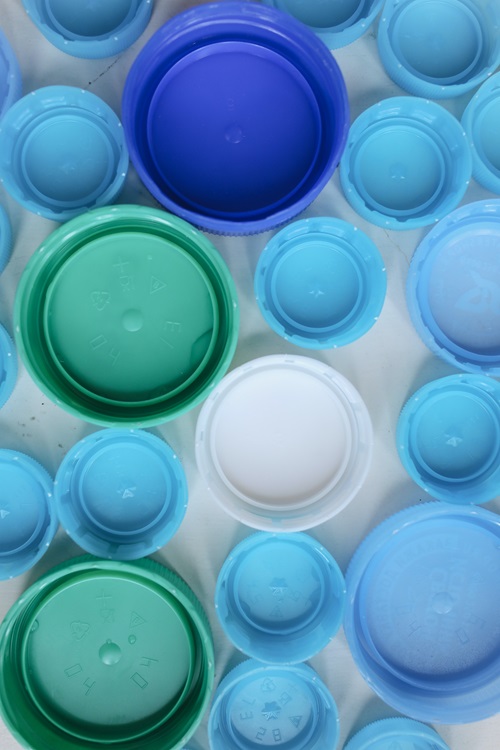 Image of blue, white and green bottle lids