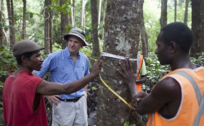 Three men talking in a forest. 