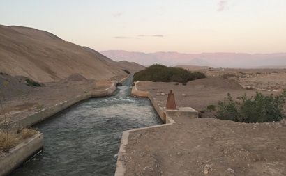 A channel full of water in a dry mountainous landscape