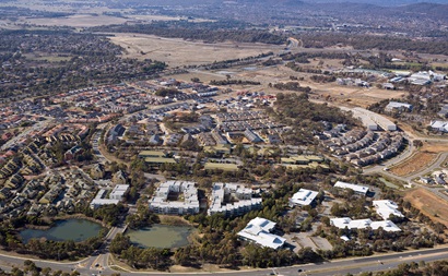 Aerial view of a development near undeveloped area with mountains and trees