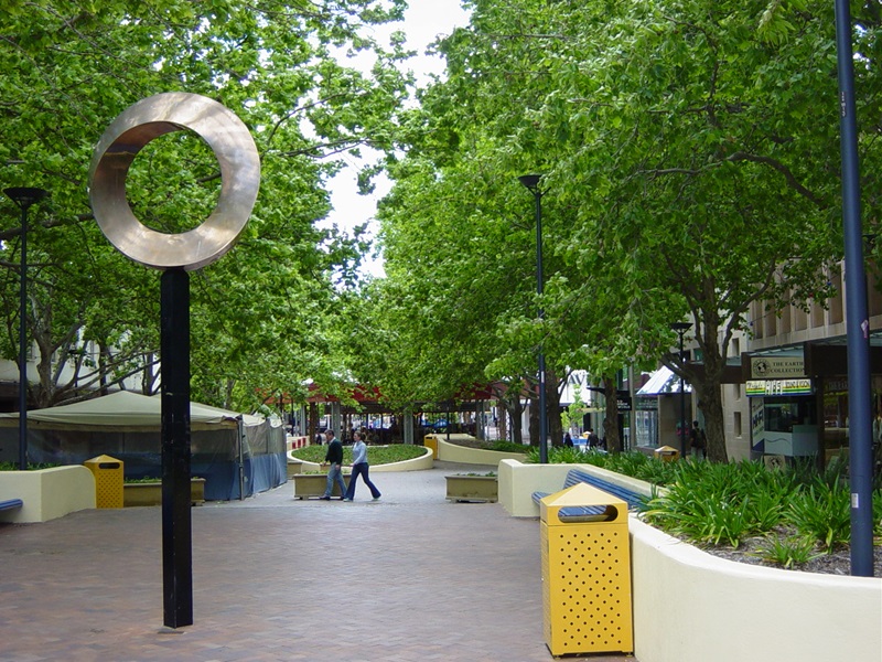 An urban pedestrian mall planted with trees and other vegetation