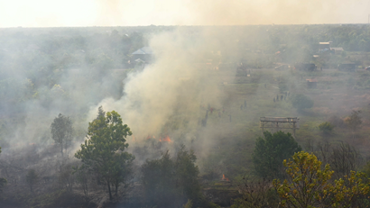 Firefighters battle a peat fire in Indonesian peatlands near a community.