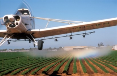 Plane flies over crops spraying them with a control agent