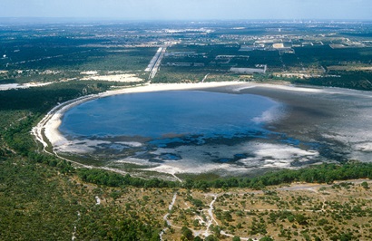 Small groundwater lake in foreground with Perth suburbs in background