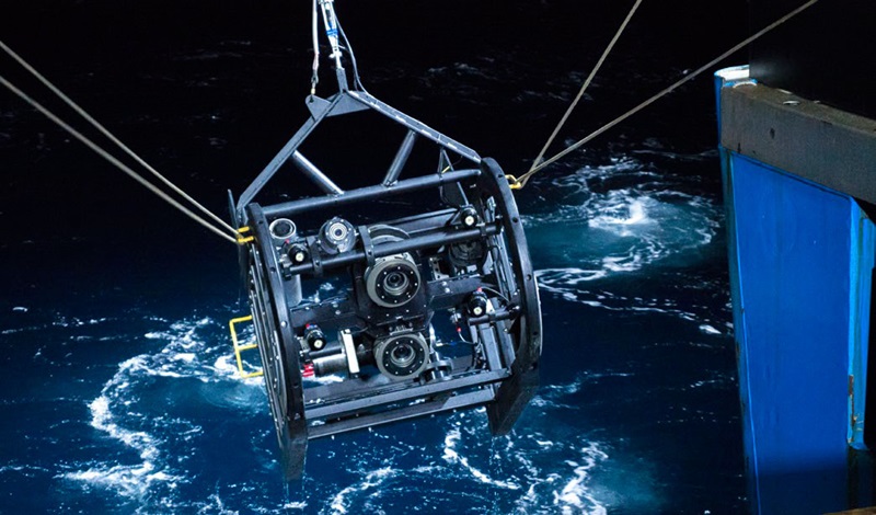Video rig being lowered into water.