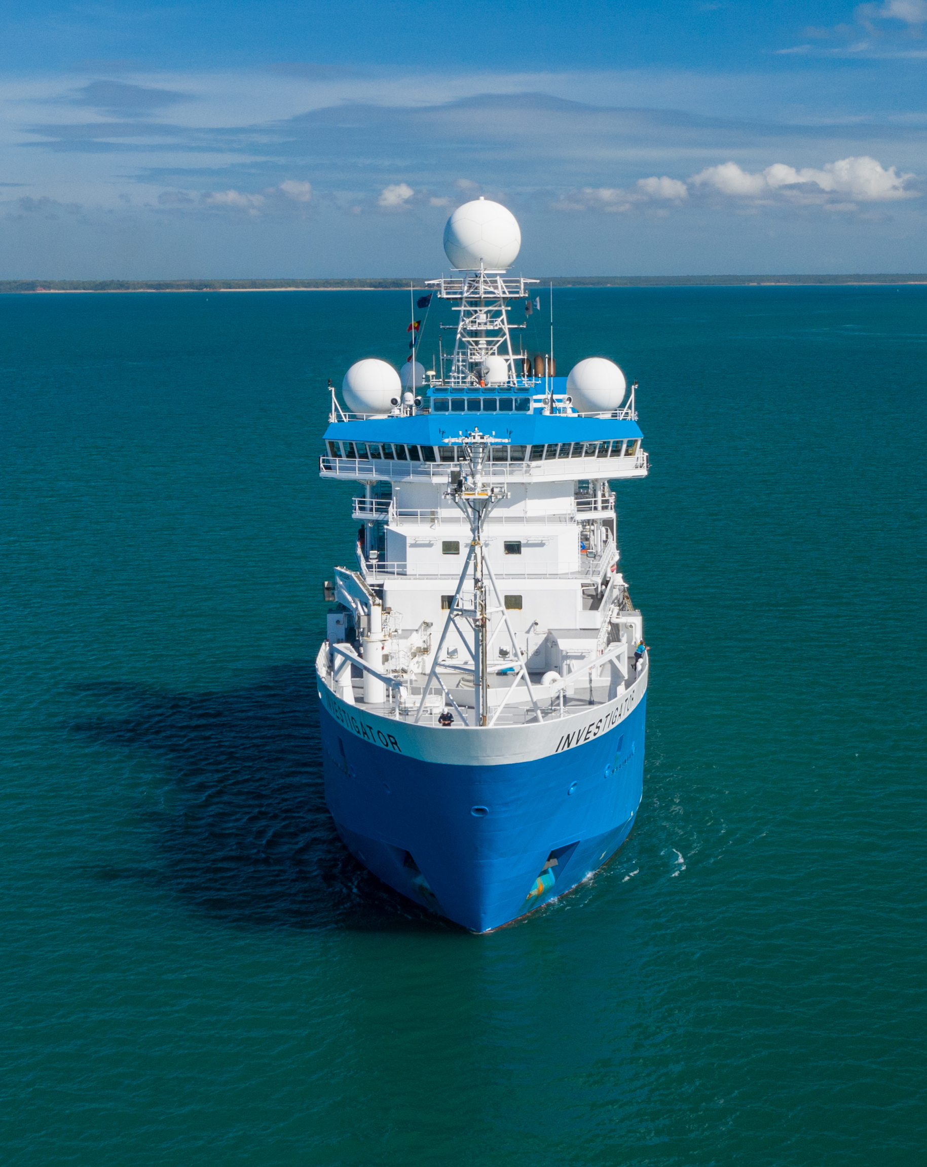 A blue and white ship on a blue ocean.