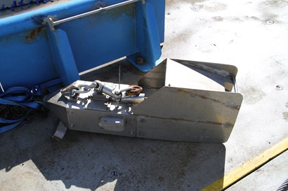 A shiny silver piece of scientific equipment sits on the deck of a ship.