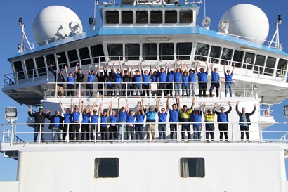 The team standing on the upper decks with the hands waving