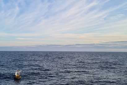 A blue and yellow piece of scientific equipment floats on the ocean surface.
