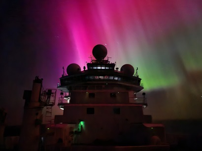 An aurora australis in the sky above a ship.