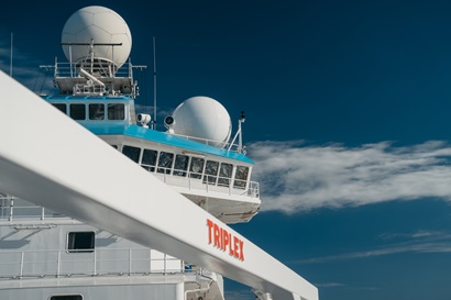 The superstructure of a white ship with a bright blue sky behind it.