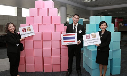 Three people standing in front of blocks signifying a country's material usage