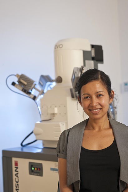 Female scientist in front of QEMSCAN equipment