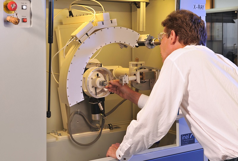 Operator looking down eye-piece of x-ray diffraction analyser