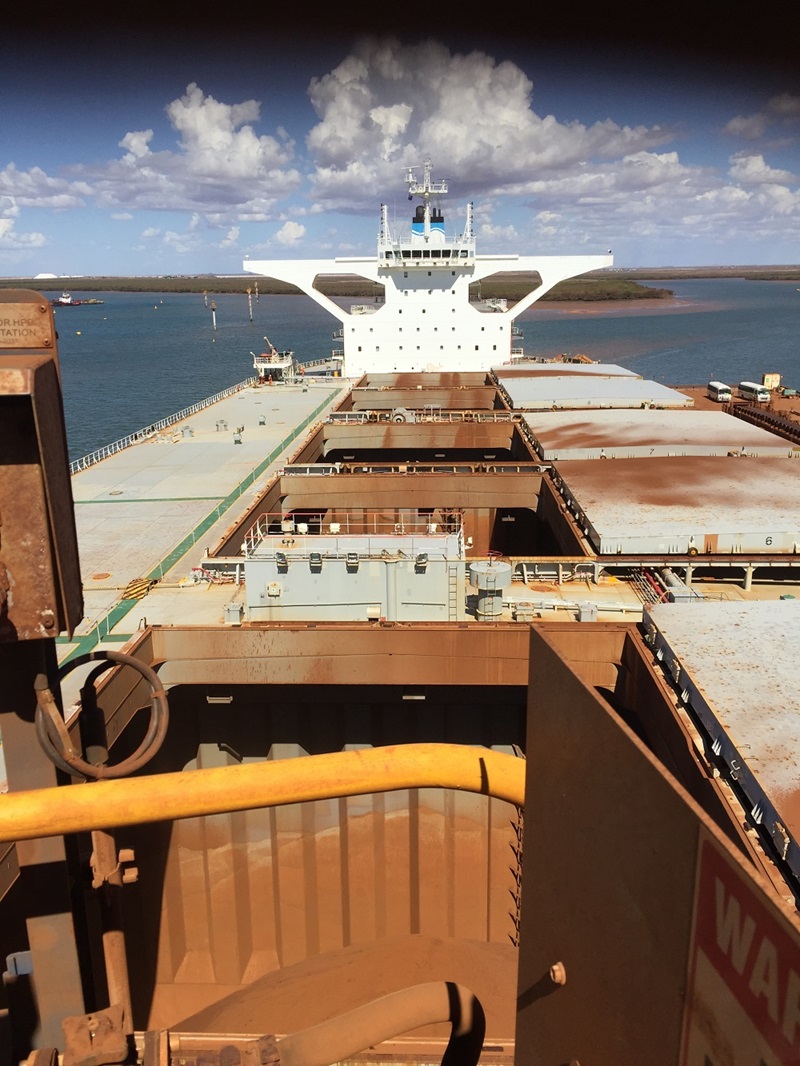 Large cargo ship being loaded with iron ore