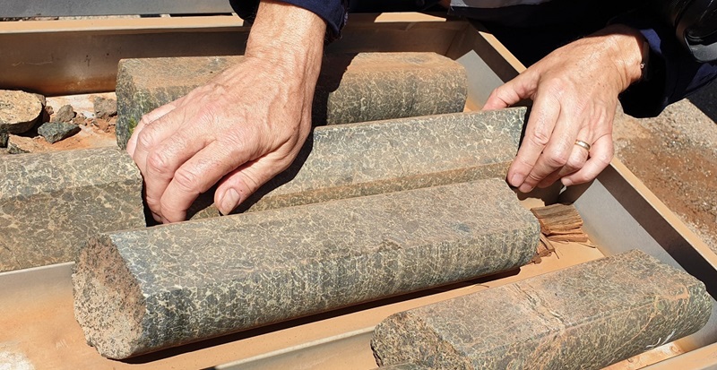 close up of hands handling cylinders of rock core samples