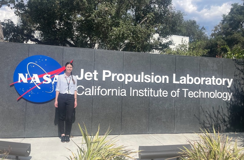 Woman standing beside sign saying NASA's Jet Propulsion Laboratory, California Institute of Technology