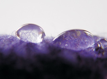 Two water droplets sitting on a piece of fibre