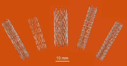 Five different sized and shapped tiny metal stents laid out on orange background 