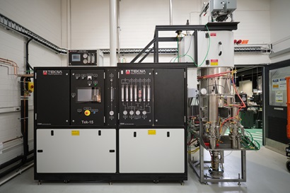 large square-shaped, black and cream coloured industrial machinery in a workshop environment. Lots of switches and tubes. 