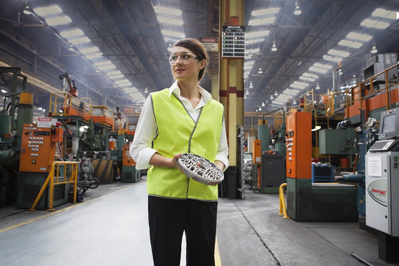 Woman holding casting in automotive production facility 
