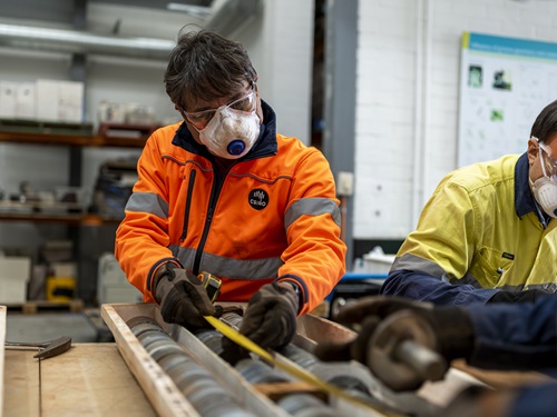 Man measuring drill core in sample tray