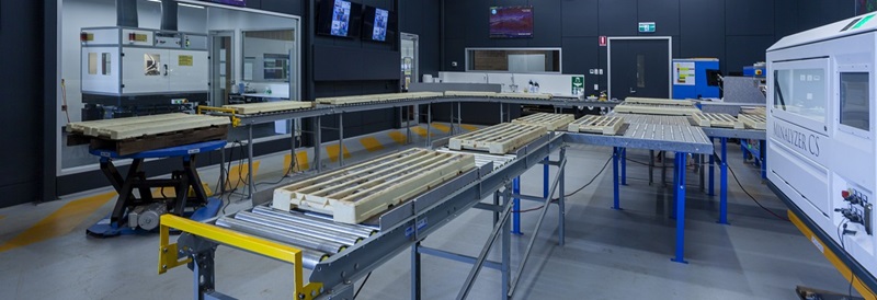 Interior of drill core lab showing conveyor belt with drill core samples surrounded by various instruments