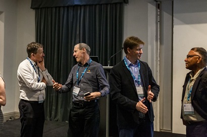 Four people standing casually talking