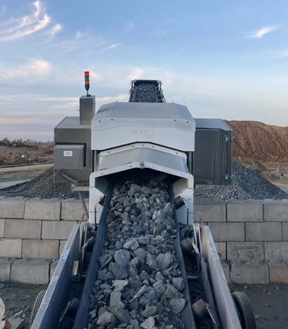 Conveyor belt of rocks going through ore sorting machine