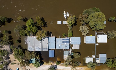 An aerial shot of a flooded river and submerged houses