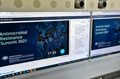 Two screens displaying the holding slide for the AMR Summit 2021