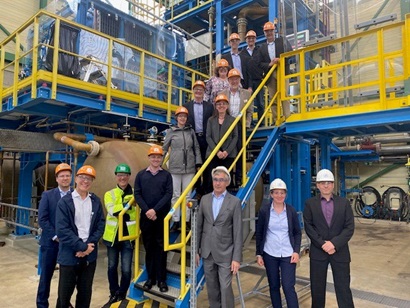 Photo of people wearing hard hats posing on the stairs at an industrial facility