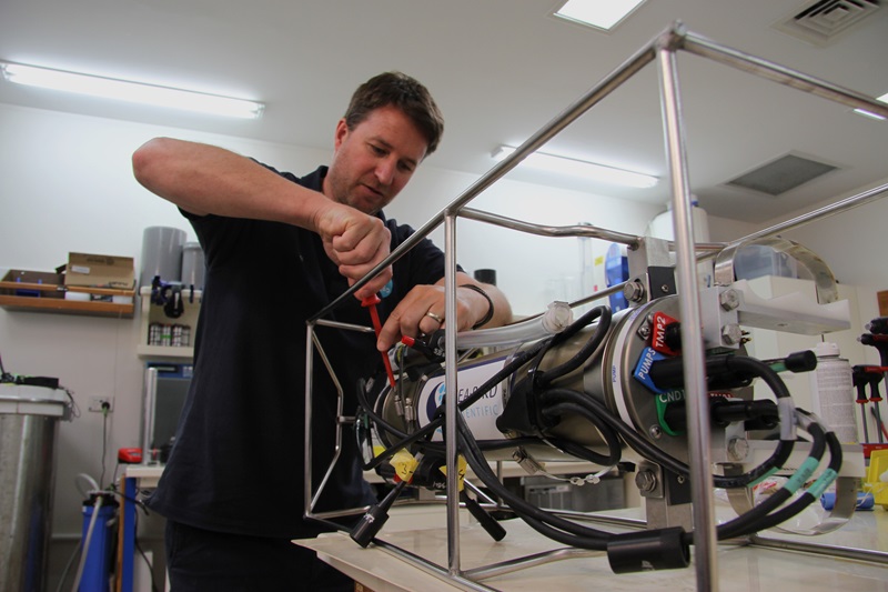 A person working on a piece of scientific equipment in a laboratory.