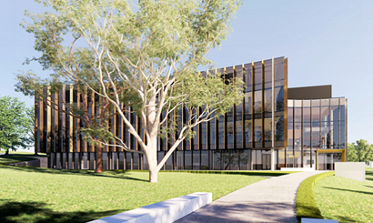 A four story building in a landscape of lawn and trees.