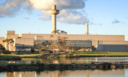 Southern view of the multi storied concrete AAHL facility with a lake in the foreground.