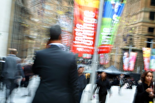 A busy pedestrian street, blurred by motion.