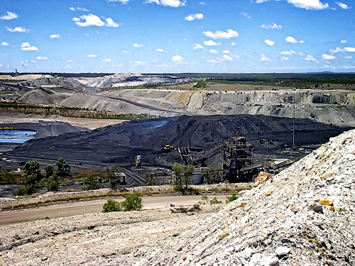 Mine water storage pond with large coal hill in the background.
