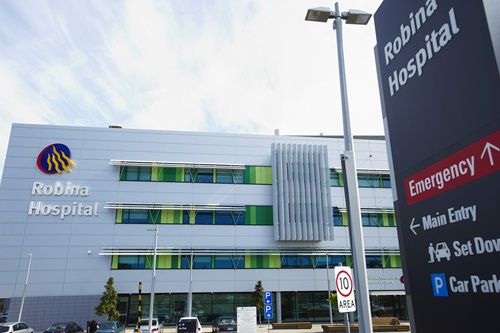 The outside of a multi storey building with signage showing Robina Hospital and direction signs