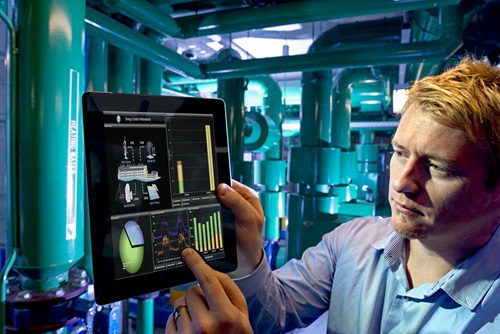 A man interacts with a tablet interface in an energy facility.