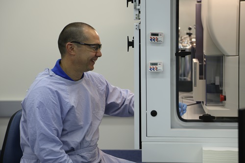 Matt Bruce, a CSIRO immunology researcher, loads a sample into the cell sorter to isolate virus fighting cells.