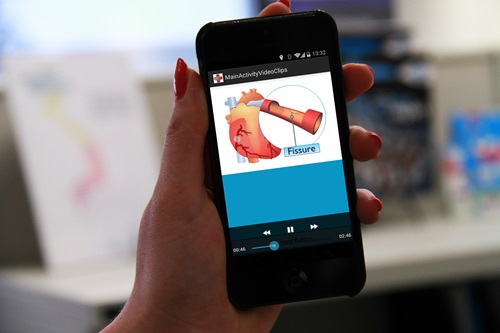 Person holding smartphone using the app which contains multimedia that educates patients about disease symptoms and management.