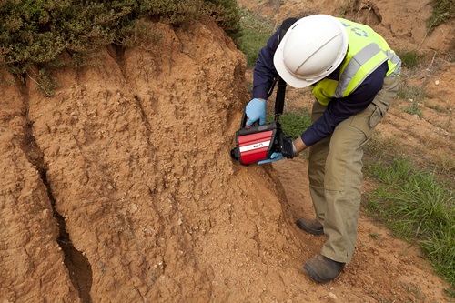 Scientist holding the RemScan device which uses an infrared signal to directly measure petroleum contamination in soil.