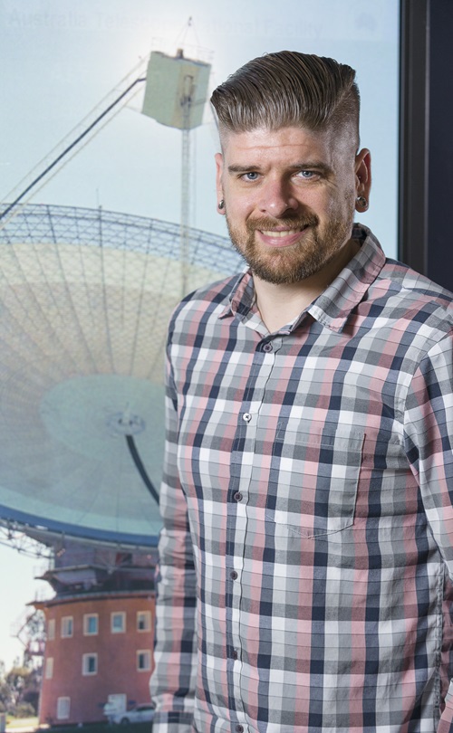 Dr Ryan Shannon standing in front of a radio telescope.