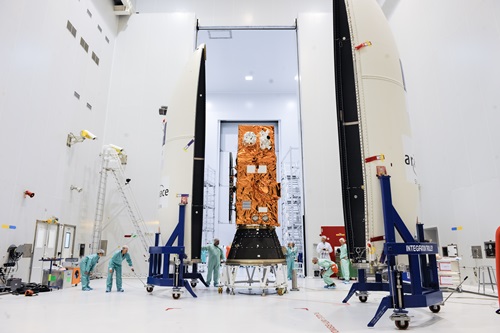 Sentinel-2A satellite being prepared for launch in a laboratory hanger by people in protective overalls and head coverings.