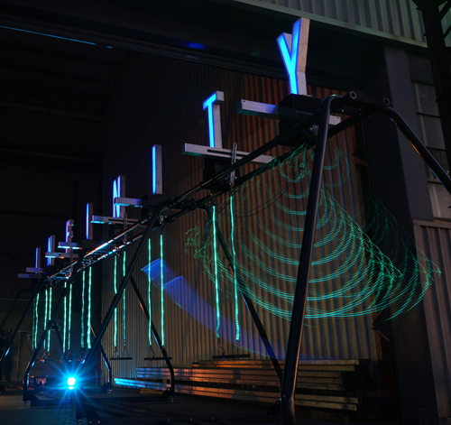 Blurred motion in green light of the Infinity swing.