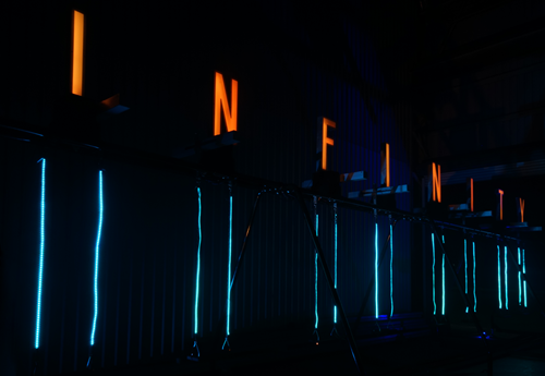 Swing with words Infinity glowing in orange light across the top. 