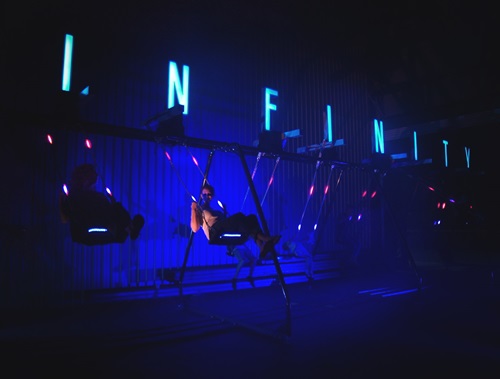Two people swinging on the Infinity swing.